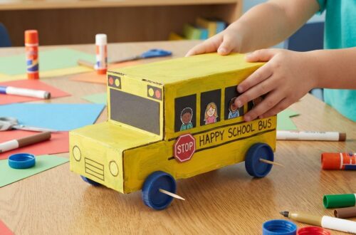 # How to Make a School Bus That Moves Using Cardboard Making a school bus that moves using cardboard is a fun, creative, and educational project for children. It combines arts and crafts with simple mechanical ideas, allowing students to build a small model vehicle from materials that are easy to find at home or in the classroom. The project can be made from an old cardboard box, paper, bottle caps, wooden sticks, glue, and other recycled materials. With a little imagination, an ordinary piece of cardboard can become a colorful school bus with wheels that actually move. This project is especially interesting because it is not only about decoration. A moving cardboard school bus introduces children to basic ideas about wheels, axles, balance, movement, and design. Children can learn how vehicles work while enjoying a hands-on activity. They can also customize their bus with windows, doors, seats, lights, a driver, and a school name. ## Understanding the Project A cardboard school bus is a miniature model of a real school transportation vehicle. The basic structure can be made from thick cardboard, while the wheels can be made from bottle caps, cardboard circles, or other round recycled materials. To make the bus move, the wheels need to be attached to axles that can rotate freely. The simplest design uses two axles passing underneath the body of the bus. Each axle connects two wheels. When the wheels turn, the bus can roll forward or backward. Children can make the bus move by pushing it gently with their hands. Older students can also explore simple mechanical methods, such as using a rubber-band mechanism or a small low-voltage motor under adult supervision. However, a hand-pushed model is often the easiest and safest version for younger children. ## Materials Needed The materials for this project are inexpensive and easy to find. The main material is strong cardboard. An old delivery box, cereal box, or packaging box can be reused for the bus body. Other useful materials include colored paper, scissors, glue, tape, a ruler, a pencil, markers, and crayons. Bottle caps can make excellent wheels because they are already round and strong. Alternatively, children can cut circles from cardboard. For the axles, straight wooden sticks, paper tubes, or sturdy straws can be used depending on the size of the model. Drinking straws can act as small axle holders, allowing the axle to rotate more easily. Additional decorations may include black paper, white paper, stickers, small pieces of foam, yarn, buttons, and recycled packaging materials. ## Planning the School Bus Before cutting the cardboard, it is helpful to make a simple plan. Children should decide how large the bus will be and where the wheels, windows, doors, and other parts will go. A rectangular shape works well for the main body. The front can be slightly rounded or slanted to make the bus look more realistic. The roof can remain flat, or another piece of cardboard can be shaped to create a curved appearance. The size of the wheels should also be considered during planning. If the wheels are too small, they may not support the bus properly. If they are too large, they can interfere with the body. Drawing the design first makes construction easier and reduces wasted cardboard. ## Building the Bus Body The bus body can be made from several pieces of cardboard. A large rectangular piece can form the main body, while smaller pieces can create the front, back, roof, and sides. A simple method is to cut one long piece with folding lines. The cardboard can then be folded into a box-like shape. Another method is to cut each wall separately and glue them together. The edges should be secured with strong tape or glue. Children should allow the glue to dry before adding heavy decorations. The body should be strong but not too heavy. A very heavy bus may make the wheels difficult to turn. ## Creating the Windows Windows give the cardboard school bus its recognizable appearance. Several rectangular windows can be drawn along both sides. Children can cut out the windows completely or simply draw them using a dark marker. If they want a more detailed model, transparent plastic from clean packaging can be attached behind the openings. Each window can contain a small paper passenger. This creates the appearance of children sitting inside the bus. The front windshield can be made slightly larger than the side windows. A rear window can also be added. ## Making the Wheels The wheels are one of the most important parts of the moving bus. Four wheels are enough for a simple model, although larger models can use six wheels. Bottle caps are a convenient choice because they are already circular. If bottle caps are unavailable, students can draw circles on cardboard using a cup or another round object as a guide. The circles can then be carefully cut out. The wheels should be approximately the same size. This helps the bus remain balanced. The wheels can be decorated with black paper or markers. Small white circles in the center can represent hubcaps. ## Creating the Axles The axles allow the wheels to rotate. Two straight sticks can be used, one for the front wheels and one for the rear wheels. Small pieces of drinking straw can be attached underneath the cardboard body. The axle is then passed through the straw. Because the straw is smooth inside, the axle can rotate more easily. The wheels are attached to the ends of the axle. They should be fixed securely but in a way that still allows the axle to rotate. This part of the project introduces an important mechanical idea an axle supports the wheels and allows them to turn together. ## Testing the Movement Once the wheels are attached, the bus should be tested before adding too many decorations. Place it on a smooth, flat surface and gently push it. If it moves forward smoothly, the basic mechanism is working correctly. If it turns to one side, one wheel or axle may not be aligned properly. If the wheels do not turn, the axle may be stuck against the cardboard. The holes may need to be adjusted, or the straw supports may need to be repositioned. Testing early is important because mechanical problems are easier to fix before the model becomes heavily decorated. ## Adding the School Bus Colors After the structure and wheels work properly, children can decorate the bus. Traditional school buses are often yellow, making yellow paper or paint a natural choice. However, children can create their own colorful designs. They might use blue, green, orange, or another color. The important thing is that the bus should be easy to recognize. A black strip along the side can make the model look more realistic. Black lines can also separate the windows. A school name can be written on the side. Children might invent a name such as “Happy School Bus” or use the name of their school. ## Adding Doors and Lights A small door can be drawn near the front or side of the bus. It can be made from cardboard and attached with tape so that it opens and closes. Headlights can be represented with small white or yellow circles. Red circles at the back can represent rear lights. A stop sign can also be added to the side of the bus. These small details help children understand the different safety features found on real vehicles. ## Creating a Miniature Driver and Passengers The bus becomes more interesting when it has people inside. Children can draw small passengers on paper and cut them out. The driver can sit at the front behind the windshield. Several children can be placed behind the driver. For a three-dimensional effect, tiny cardboard seats can be made inside the bus. If the side windows are open, viewers can see the passengers sitting inside. This part of the project can also encourage storytelling. Children can imagine where the bus is going and create a story about the students traveling to school. ## Making the Bus Move in Different Ways The simplest moving cardboard school bus is pushed by hand. This is ideal for younger children and requires no complicated equipment. Another possibility is a rubber-band-powered mechanism. A rubber band can store energy when it is twisted and can release that energy to turn an axle. This design requires careful construction and adult assistance. Older students can experiment with a small battery-powered motor designed for educational projects. A motor can turn the wheels and make the bus move without being pushed. When using batteries, wires, motors, or electrical components, children should work with an adult and use only safe, low-voltage educational equipment. ## Learning Through the Project The moving cardboard school bus is more than a craft. It can become a simple science and engineering lesson. Children learn that wheels reduce friction and make transportation easier. They discover that an axle connects wheels and helps them rotate. They also learn that balance and alignment are important when building a moving object. The project introduces children to engineering design. They make a plan, build a model, test it, identify problems, make changes, and test it again. This process teaches an important lesson mistakes are part of learning. If the first version does not move correctly, children can investigate the problem and improve the design. ## Environmental Benefits of Cardboard Crafts Using cardboard for the school bus also encourages recycling. Instead of throwing away packaging, children can reuse it as a building material. This teaches an important environmental message. Many household objects can have a second life when people use creativity and imagination. Reusing cardboard also makes the project inexpensive. Families and schools do not need to purchase special construction materials. The activity can therefore combine creativity, science, and environmental education in one project. ## Turning the Project Into a Classroom Activity Teachers can turn the cardboard bus into a larger classroom challenge. Students can work individually or in small groups to create different buses. Each group can test how far its bus travels when pushed with the same amount of force. Students can measure the distance and compare the results. They can also experiment with different wheel sizes, axle positions, and bus weights. This turns a simple craft into an introduction to scientific observation and fair testing. Students can record their results and discuss why some designs moved farther than others. ## Safety During Construction Safety should always be considered when making cardboard crafts. Scissors should be used carefully, and younger children may need adult assistance when cutting thick cardboard. Hot glue guns should only be used by adults or under close adult supervision. Children should also avoid sharp tools and unsafe electrical components. The work area should be clean and organized. Small pieces of cardboard, glue, and other materials should be removed when the project is finished. ## Conclusion A school bus that moves using cardboard is an exciting project that brings together creativity, recycling, science, and simple engineering. Starting with an ordinary piece of cardboard, children can create a miniature vehicle with a body, windows, wheels, axles, seats, passengers, and decorations. The moving feature makes the project especially enjoyable because children can test their creation instead of simply looking at it. They can push the bus across a table, observe how the wheels turn, identify problems, and improve the design. The project also teaches valuable skills. Children practice measuring, cutting, folding, gluing, decorating, planning, and problem-solving. They learn that successful construction requires patience and testing. Most importantly, they discover that science and creativity can work together. A cardboard school bus can become much more than a small toy. It can be a classroom science experiment, an art project, a recycling activity, or a demonstration of basic mechanical principles. With simple materials and a little imagination, children can transform recycled cardboard into a fun moving vehicle while learning important lessons about design, motion, teamwork, and responsible use of materials.